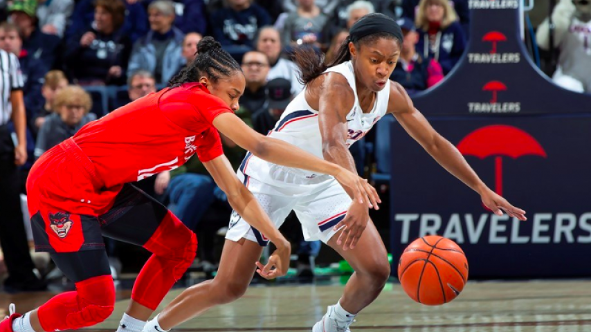 Crystal Dangerfield get away from a defender in a game for UConn women's basketball